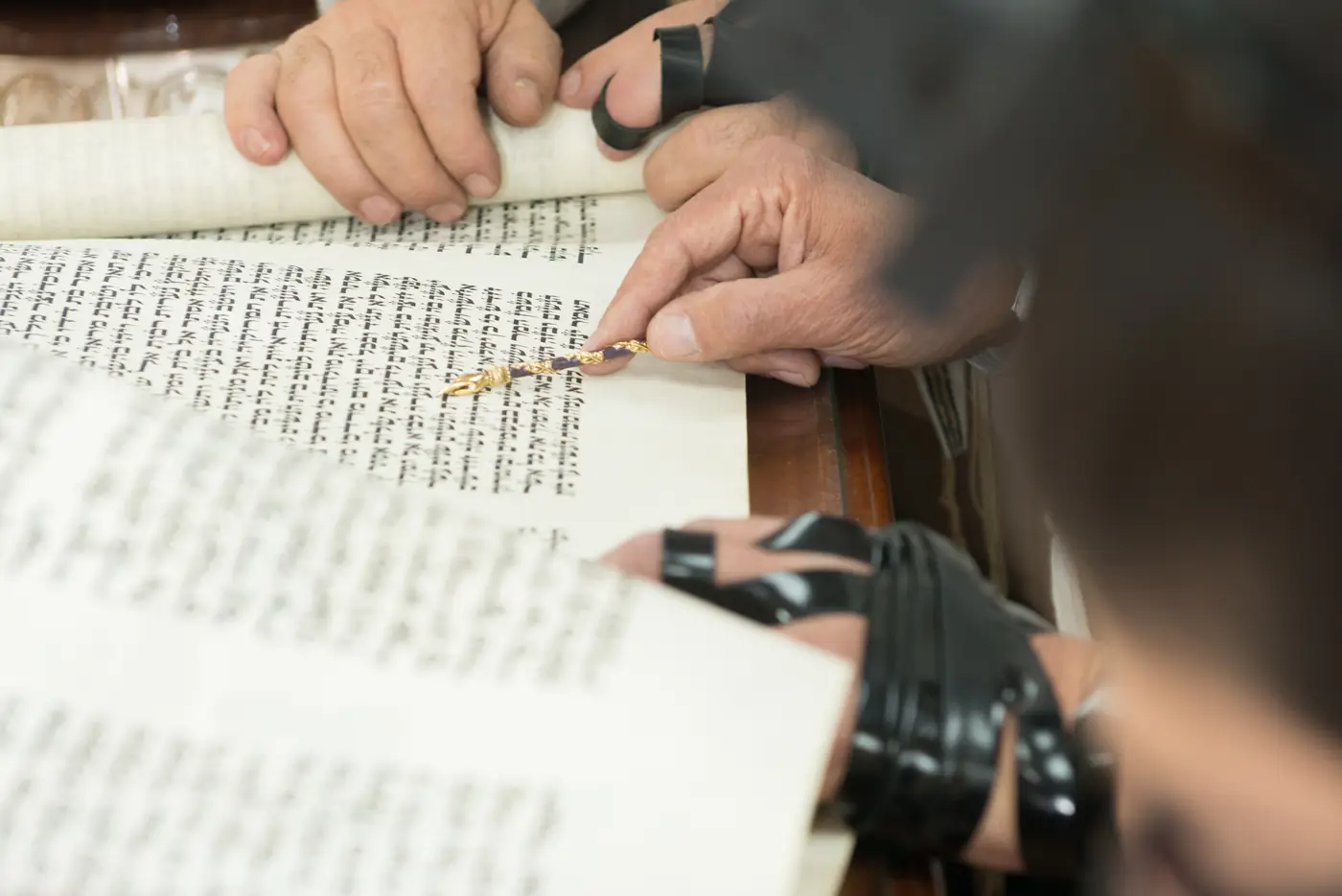 מצביע זהב על ספר תורה בזמן קריאת הפרשה